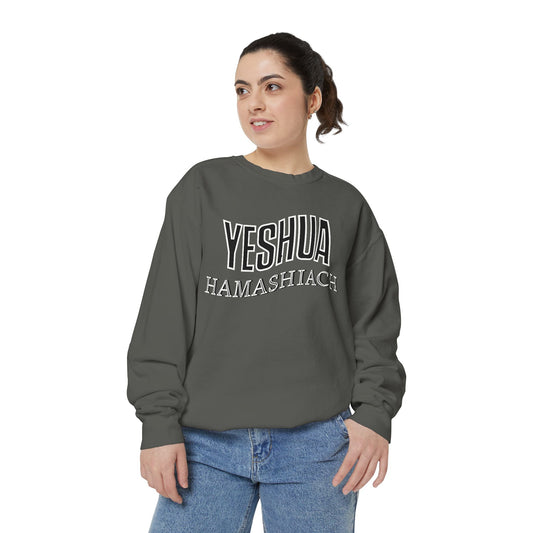 A person wearing a gray sweatshirt with 'YESHUA HAMASHIACH' written across the front in bold letters.
